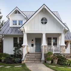 a white house with stone steps leading up to the front door