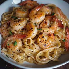 a white bowl filled with pasta and shrimp