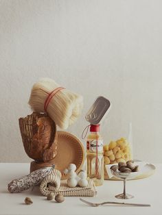 an assortment of food items displayed on a white table with spoons and utensils