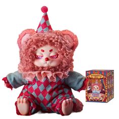 a teddy bear with pink hair wearing a clown hat and sitting next to a box