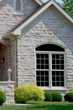 a brick house with white trim and arched windows