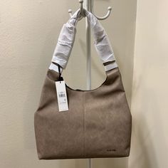 Casual Yet Trendy Hobo Shoulder Bag Perfect Size For Everyday Use Throw All Of Your Essentials Into This Fun Hobo & Get On With Your Day High Quality Vegan Leather 2 Interior Slip Pockets 1 Interior Zip Pocket Removable Pouch Magnetic Closure Approx Dims 13" H X 17" W X 3" D, 13" Handle Drop New W/Tags Better Pricing On Ig Ig: @Ari_sweirdmysteries Calvin Klein Rectangular Shoulder Bag For Daily Use, Taupe Hobo Tote Bag With Removable Pouch, Calvin Klein Rectangular Bags For Daily Use, Calvin Klein Satchel Shoulder Bag With Removable Pouch, Calvin Klein Tote Bag With Removable Pouch, Calvin Klein Rectangular Shoulder Bag, Calvin Klein Tote Bag With Top Carry Handle, Calvin Klein Shoulder Bag With Removable Pouch For Travel, Calvin Klein Travel Shoulder Bag With Removable Pouch