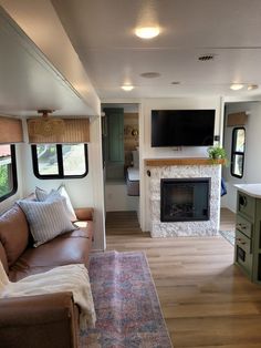 a living room filled with furniture and a flat screen tv mounted on the wall next to a fire place