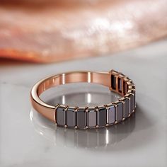 a close up of a ring on a table with a baguette in the background