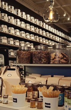 the shelves are filled with many different types of spices and coffee beans in glass jars