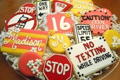 decorated cookies in the shape of road signs on a cake platter with white frosting