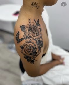 a woman's stomach with roses and butterflies tattooed on her side, while she is sitting down