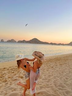 two women on the beach playing with each other