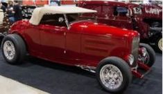 an old model red car on display at a car show