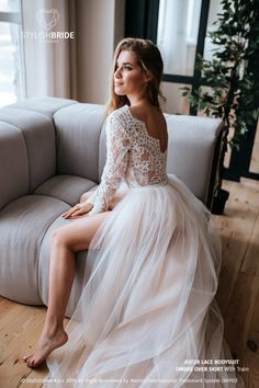 a woman sitting on top of a couch wearing a dress