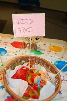 a basket filled with candy sitting on top of a table next to a sign that says bird food