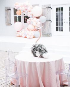 a white table topped with a cake next to chairs