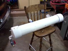 a large white object sitting on top of a wooden chair next to a parked car