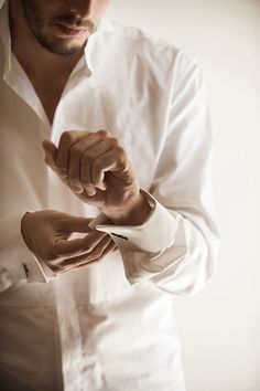 black and white photograph of a man adjusting his shirt