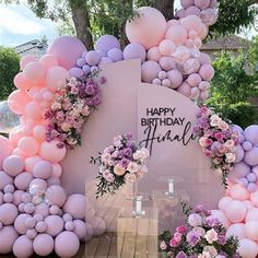 an outdoor birthday party with balloons and flowers