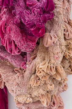 two teddy bears with pink and brown ruffles hanging on a wall next to each other