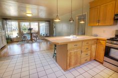 a kitchen with wooden cabinets and tile flooring