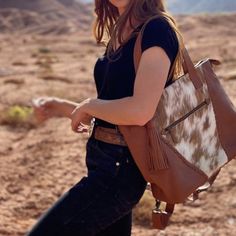 Designed for urban and western cowgirls alike, functionality and beauty collide in the Indy Carryall. We created this tote to move with you through all phases of cowgirlhood, from the baby-makin' years to work life, traveling, and beyond. Featuring structured leather and the best handpicked cowhides, this carryall has the versatility to be worn as a backpack or a tote. The roomy interior lets you keep bottles (or beer!) cold or warm, with enough pockets to fit all your essentials. Outside, you’l Western Style Rectangular Travel Bag, Western Style Shoulder Bag For Everyday, Western Style Rectangular Shoulder Bag For Travel, Western Style Satchel Bag For Travel, Western Brown Bags For Fall, Western Style Brown Bag For Fall, Fall Travel Shoulder Bag With Leather Backing, Western Saddle Bag For Everyday Use, Western Style Saddle Bags For Everyday Use