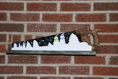 a knife with snowmen on it sitting on top of a shelf next to a brick wall