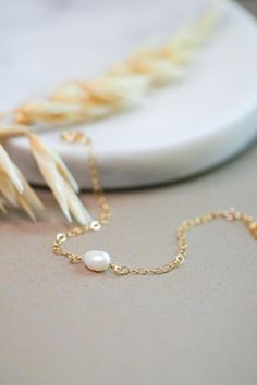 Lily Pearl Bracelet  Made in the USA using long lasting materials. 14k Gold-filled findings 8mm Freshwater pearl Measure your wrist before ordering! Choose from: 6" + .75" extender 6.5" + .75" extender 7" + .75" extender 8" + .75" extender This bracelet is made specifically for you, please allow 2-3 business days for your jewelry to be handmade before it is shipped.  All of the materials are hypoallergenic, safe for sensitive skin. What is gold-filled? Gold-filled is a great option for those wanting a quality material without paying the cost of solid karat gold. Gold-filled products are legally required to be 5% or 1/20 gold by weight. The gold is bonded by heat and pressure to brass or sometimes sterling silver. This makes the product much more durable and long lasting than gold-plated. Wedding Jewelry Bracelets, Wedding Bracelet, Pearl Bracelet, Bracelet Making, Freshwater Pearls, Sensitive Skin, Wedding Jewelry, Gold Filled, Accessory Gift