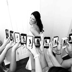 a group of people holding up cell phones in front of a woman's face