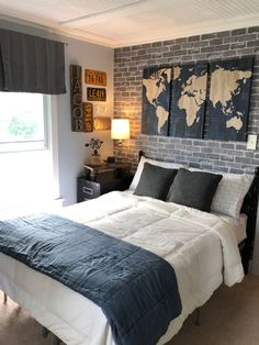 a bedroom with a brick wall and blue comforter on the bed in front of a window