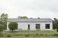 a white house sitting on top of a lush green field