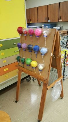 a wooden easel with lots of different colored balls on it