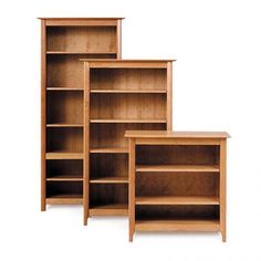 three wooden bookshelves sitting next to each other