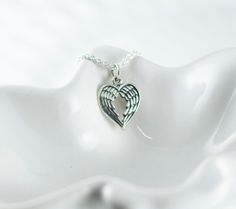 "Keep your angel close to your heart with this sweet memorial necklace. This sterling silver angel wing pendant is in the shape of a heart. Perfect remembrance gift. Pendant/charm measures approximately 1/2\". ♥ ♥ ♥ Check out more necklaces here: https://www.etsy.com/shop/woobiebeans?section_id=10231994 ♥ ♥ ♥ Or visit my entire shop here: https://www.etsy.com/shop/woobiebeans Need something a little different? Convo me with any custom orders, and I will work with you to come up with a completely Sterling Silver Heart Charm Necklace For Memorial, Winged Sterling Silver Necklace For Gift, Silver Angel Wings Necklace As Gift, Angel Wings Heart Pendant Jewelry For Gifts, Heart-shaped Angel Wings Jewelry Gift, Silver Heart Pendant Necklace For Remembrance, Sterling Silver Necklace For Remembrance, Valentine's Day Angel Wings Jewelry Gift, Sterling Silver Heart Jewelry With Angel Wings