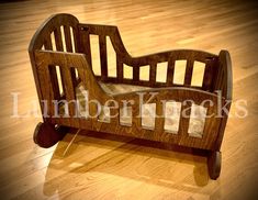 a wooden toy bed sitting on top of a hard wood floor