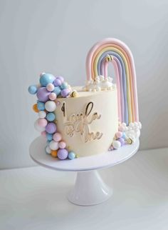 a white cake with rainbow decorations on it