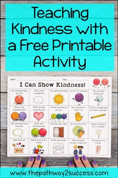 hands holding up a poster with the words teaching kindness with a free printable activity