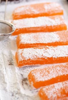 several pieces of orange cake sitting on top of a table