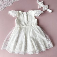 Baptism Dress For Baby Girl.  It is available in white and ivory colour. You can choose the colour in the options. It is made of natural cotton.  There are lace ruffles on the shoulders.  The skirt is made of tulle and lace and lined with natural cotton. It is a set of dress and headband. If you want the matching bloomers, bonnet, shoes, blanket, please, use the links: *bonnet: https://www.etsy.com/listing/770090500/baptism-bonnet-baptism-girl-hat?click_key=dafd0e272036d544bcf2e76615922f35c72160fa%3A770090500&click_sum=19a689c3&ref=shop_home_active_7&crt=1&sts=1 *bloomers: https://www.etsy.com/listing/770090500/baptism-bonnet-baptism-girl-hat?click_key=dafd0e272036d544bcf2e76615922f35c72160fa%3A770090500&click_sum=19a689c3&ref=shop_home_active_7&crt=1&sts=1  *blanket: https://www.etsy.com/ Elegant Baptism Dress In Solid Color, Elegant Baptism Dress, Toddler Baptism Dress, Toddler Baptism, White Christening Dress, Christening Blanket, Dress For Baby Girl, Ivory Colour, Dress For Baby