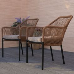 three wicker chairs sitting next to each other on a wooden floor in front of a wall