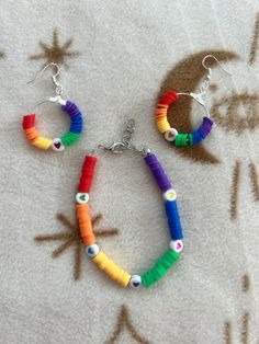 Radiate love and joy with this enchanting bracelet and earring set, adorned with vibrant rainbow colors and charming heart beads. This set is a celebration of positivity and happiness, beautifully crafted to add a pop of color to any outfit. Whether you're spreading love or simply brightening your day, this whimsical set is the perfect accessory to express your vibrant personality and embrace life's colorful moments. Everyday Heart-shaped Colorful Beads Jewelry, Everyday Multicolor Heishi Beads Jewelry, Adjustable Rainbow Heart Beads Jewelry, Playful Heart Beads For Jewelry Making, Playful Heart-shaped Colorful Beads Jewelry, Playful Jewelry With Heart Beads, Playful Heart Beads Jewelry, Everyday Rainbow Round Bead Jewelry, Everyday Rainbow Jewelry With Round Beads