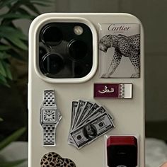 a person holding up a phone case with various items on it