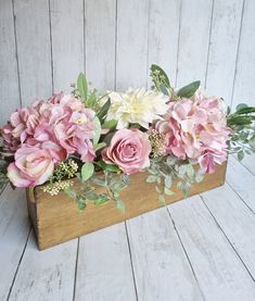 a wooden box filled with pink and white flowers