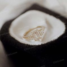 an engagement ring sitting on top of a white cloth