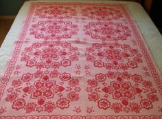 a red and white blanket on top of a bed