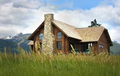 a log cabin sits in the middle of tall grass