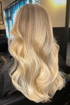 This light golden blonde hairstyle has a creamy and warm color that stands out but is also soft, with milder dark blonde roots smoothly blending into a lush fall of sunlight-kissed waves. The hair is cut into long sections to add fullness and flow, giving it a springy, lively look while highlighting the complex color - Click to see more of Get Ready to Dazzle with These 30 Captivating Butter Blonde Hair Ideas and follow us for more hairstyle ideas. // Photo Credit: Instagram @jakenugent.hair Medium Brown Hair With Blonde Babylights, Blended Blonde Hair Dark Roots, Dirty Blonde Hair With Light Highlights, Soft Butter Blonde Hair, Natural Icy Blonde Hair, Buttery Blonde With Lowlights, Short Butter Blonde Hair, Creamy Butter Blonde Hair, Warm Creamy Blonde Hair