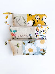 three zippered pouchs with flowers and birds on them