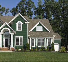 a green house with white trim and windows