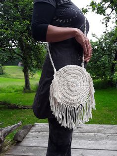 Pretty individual handbag in circular shape from macrame for hanging or as a crossbody. The bag is handmade from cotton, has a 135 cm long shoulder strap and is lockable with a zipper. Diameter of the bag 23 cm, opening with zipper 14 cm, fringe length 11 cm Colour: natural-white Weight approx. 335 gr White Handwoven Crossbody Shoulder Bag, White Bohemian Crossbody Shoulder Bag, Bohemian Cream Crochet Crossbody Bag, Festival Macrame Bags, White Crochet Crossbody Bag With Braided Handles, White Handwoven Shoulder Bag, White Macrame Shoulder Bag For Everyday Use, White Crochet Crossbody Shoulder Bag, White Crossbody Shoulder Bag For Festival