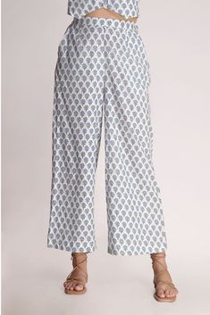 This white printed motif pant is a love story that blossoms sophistication with a tinge of charm. The relaxed fit of the pants gives a fresh look to the small motif prints on display. Mindfully crafted from cotton, it's like a superhero for the summer, ready to rescue you from sweat and stickiness. Rock this look with the Aster Printed Motif top & classy shoes or stilettos, and let the flower power spread its magic wherever you go! Material: CottonStyle/Print: Small Motif Handblock PrintPant Len Casual Cotton Printed Bottoms, Casual Printed Cotton Bottoms, Summer Floral Print Cotton Wide Leg Pants, Casual Floral Print Cotton Wide Leg Pants, Printed Cotton Summer Bottoms, Summer Printed Cotton Bottoms, Printed Cotton Bottoms For Summer, Printed Cotton Pants, Cotton Bottoms With Floral Print For Loungewear