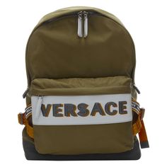 VERSACE Reflective Logo green nylon orange Greca strap backpack Reference: TGAS/C00873 Brand: Versace Designer: Donatella Versace Model: DFZ8069 DNY2R K048E Material: Nylon Color: Green, Orange Pattern: Solid Closure: Zip Lining: Nylon Extra Details: Moss green nylon. Silver Reflective with Versace leather lettering debossed at front pocket. Reflective zipper pull. Orange Greca nylon and logo straps on side of back. Leather loop handle. Wall compartment at lining. Made in: Italy CONDITION: Condi Backpack Reference, Leather Lettering, Pull Orange, Versace Leather, Zip Lining, Versace Designer, Donatella Versace, Orange Pattern, Unique Designers