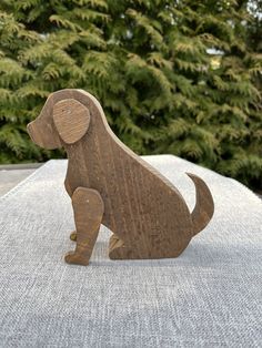 a wooden dog figurine sitting on top of a white cloth covered tablecloth