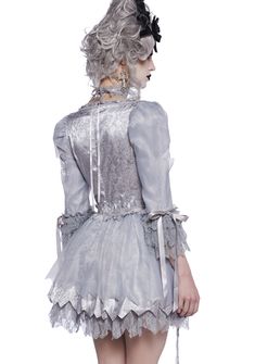 This ghostly French queen costume includes a mini dress that has a mixed sateen and lace construction, floral lace detailing, an underwire bust with a lace overlay, puffy sleeves with ribbon ties, an organza overlay with ripped details, decorative bows on the front, a layered flare skirt with tulle underneath, and a back zip closure. Includes wig with floral appliques and a lace choker with a skeleton woman cameo charm and ribbon tie closure. Marie Antoinette Ghost Costume, Marie Antoinette 2006 Costumes, Skeleton Woman, Luxury Victorian Marie Antoinette Dress With Ruffles, Gothic Marie Antoinette, Cameo Choker, Marie Antoinette Dresses, French Queen, White Victorian Marie Antoinette Dress With Ruffles